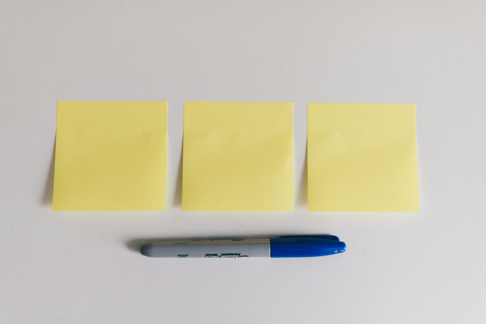 Blue sharpie beside yellow sticky notes